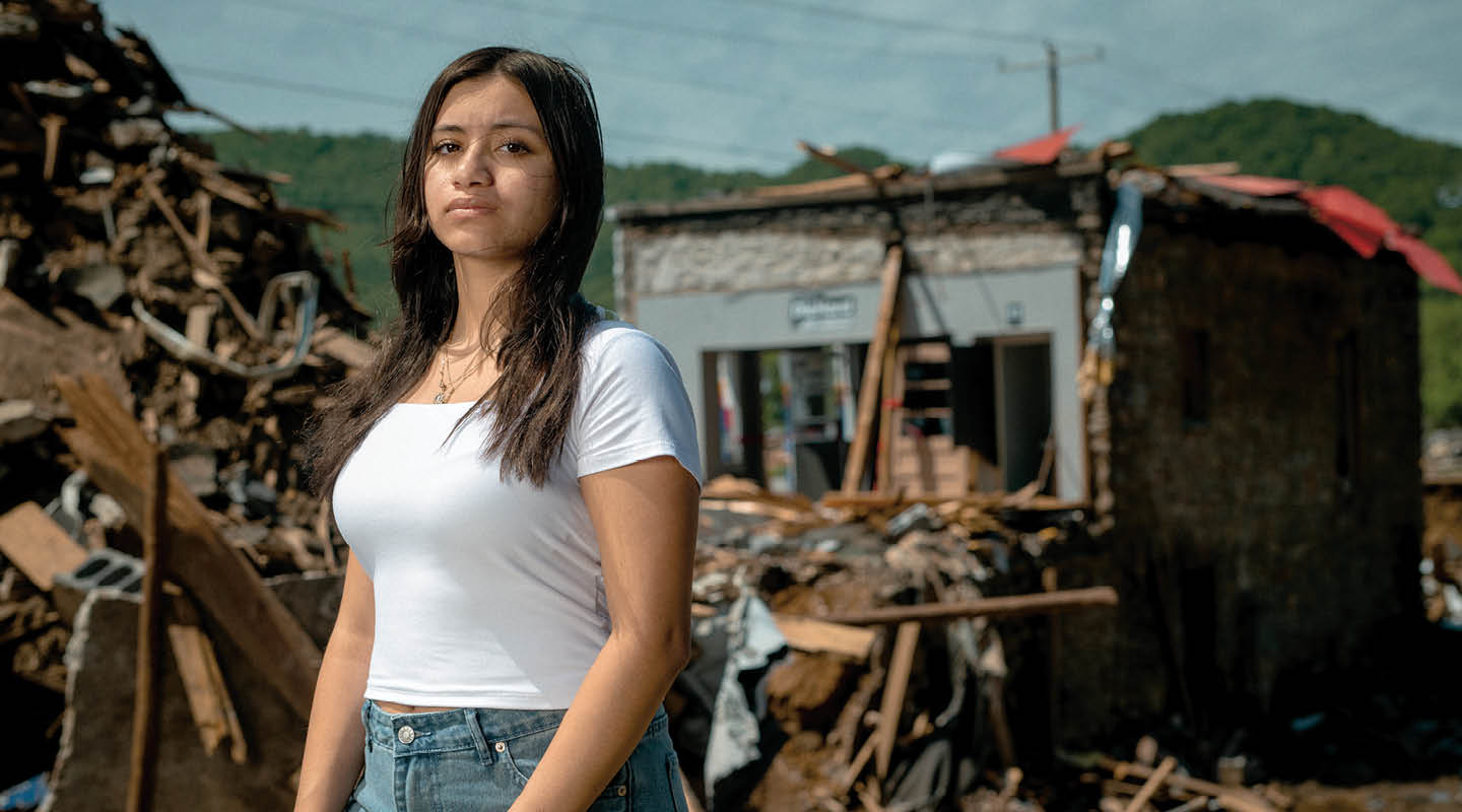 Photo of student standing in front of destruction